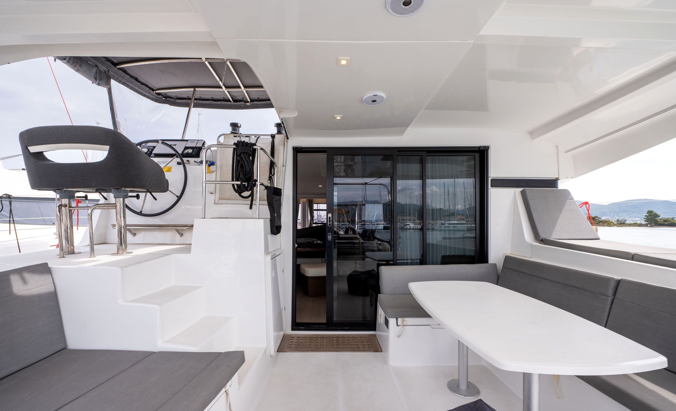A modern interior with a control station, seating area, and a view of the marina.