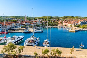 A marina with boats docked, a town in the background, and a prominent church tower. - Sun-Kissed Sailing Adventure in Split-Dalmacia, Croatia (Jesenice)