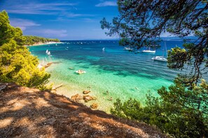 A coastal view with clear turquoise waters, boats, and a rocky shoreline. - Sun-Kissed Sailing Adventure in Split-Dalmacia, Croatia (Jesenice)