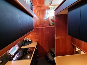 A compact kitchen with a sink, stove, and cabinets.