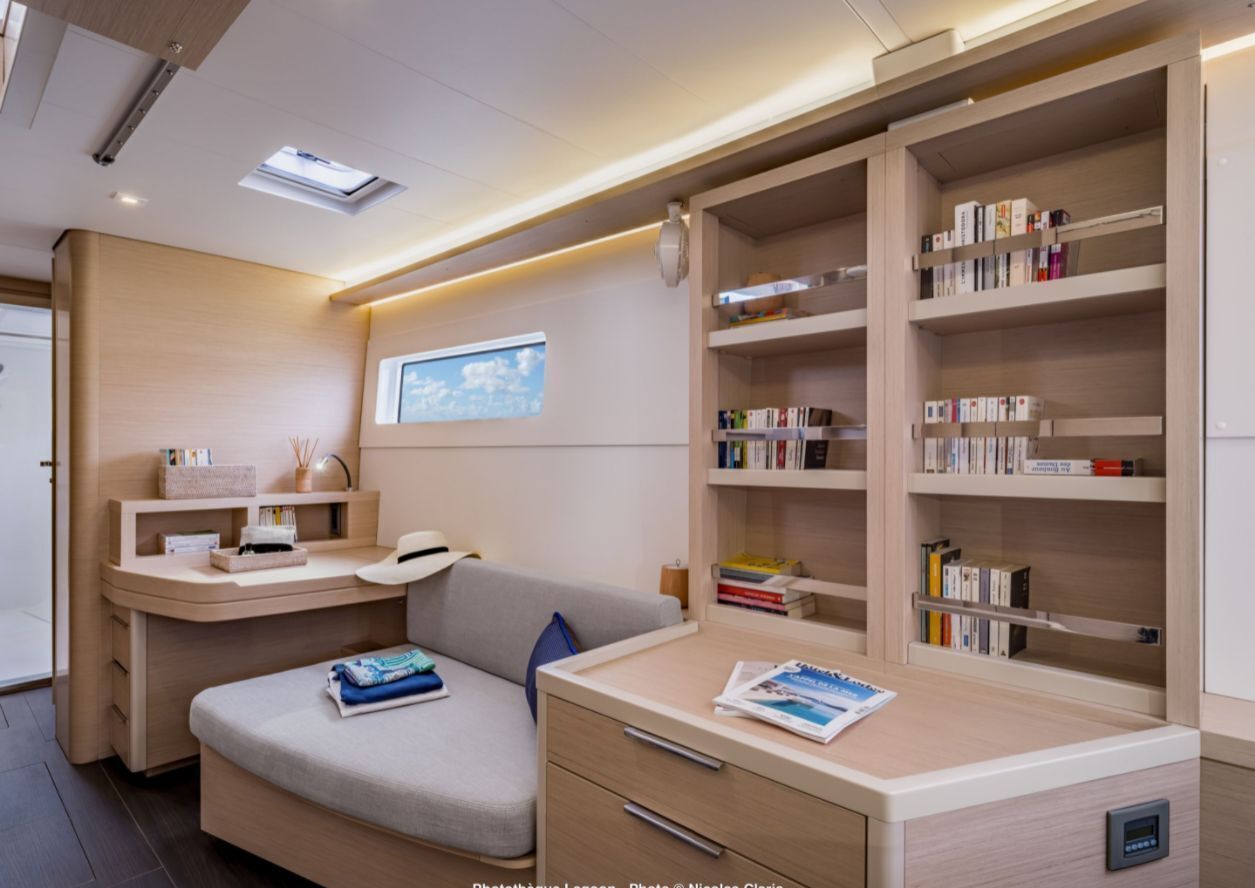 A modern bedroom with a built-in desk, a sofa, and a bookshelf.