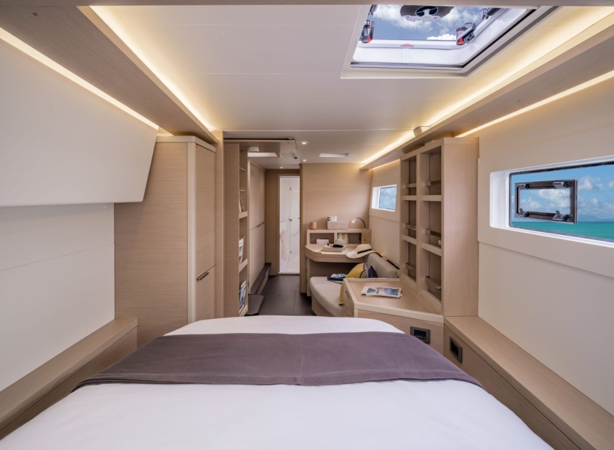 A modern interior with a bed, a desk, a vanity, and a skylight.