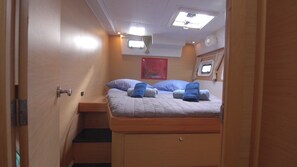 A compact cabin with a bed, a small window, and a ceiling light. - Sun-Kissed Sailing Adventure in Islas Sarónicas (Alimos)