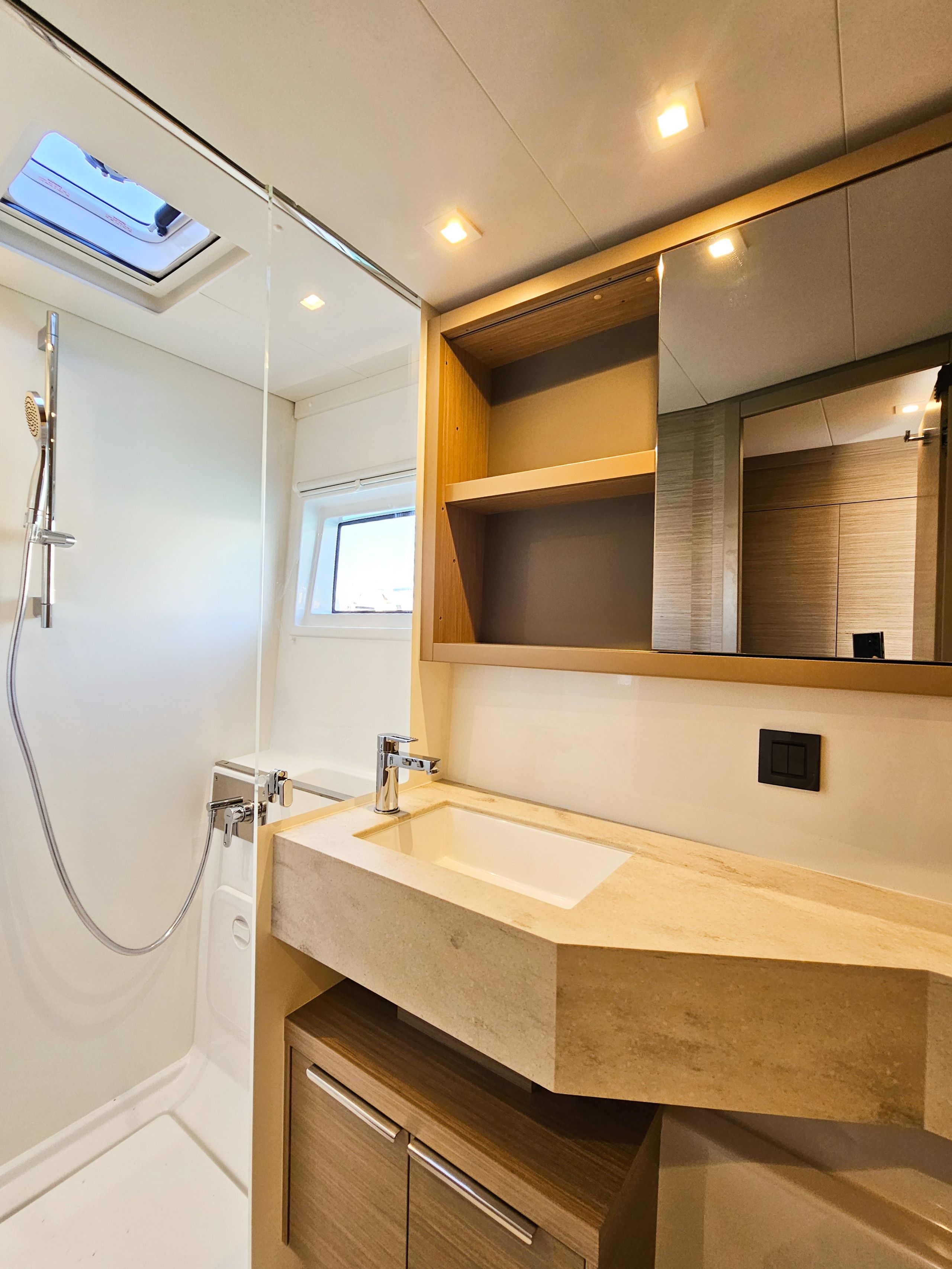 A modern bathroom with a shower, a sink, and a mirror.