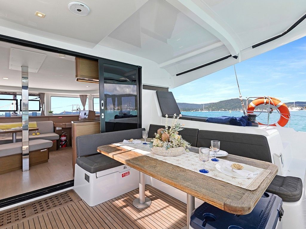 L’intérieur d’un yacht comprenant un coin repas, un canapé et une vue sur la mer.