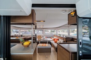 A modern RV interior with a kitchen, seating area, and large windows. - Sun-Kissed Sailing Adventure in the Ionian Islands, Lefkada (Lefkada)