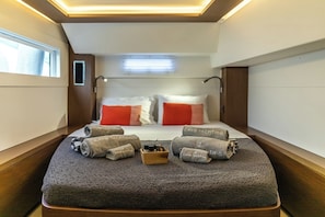 A compact, well-lit cabin with a bed, pillows, and neatly rolled towels. - Sun-Kissed Sailing Adventure in the Ionian Islands, Lefkada (Lefkada)