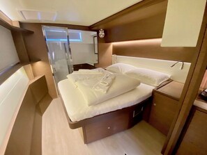 Ein kleines Schlafzimmer mit Bett, Nachttisch und Spiegel.