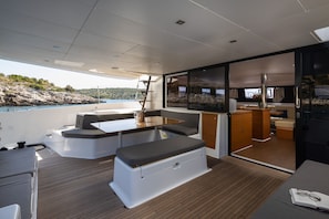 A modern boat interior with a dining area, seating, and a kitchen. - Sun-Kissed Sailing Adventure in Sibenik, Croatia (Primošten)