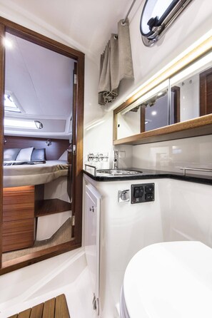 A compact, well-lit bathroom with a white sink, a mirror, and a small window. - Sun-Kissed Sailing Adventure in Zadar, Croatia (Bibinje)