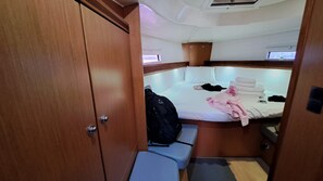 A compact cabin with a bed, a bench, a wardrobe, and a small seating area. - Sun-Kissed Sailing Adventure in the Sporades Islands from Volos, Thessaly (Volos)