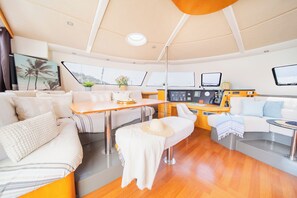 L’aménagement intérieur d’un yacht comprend un espace repas, des sièges et un poste de commande.