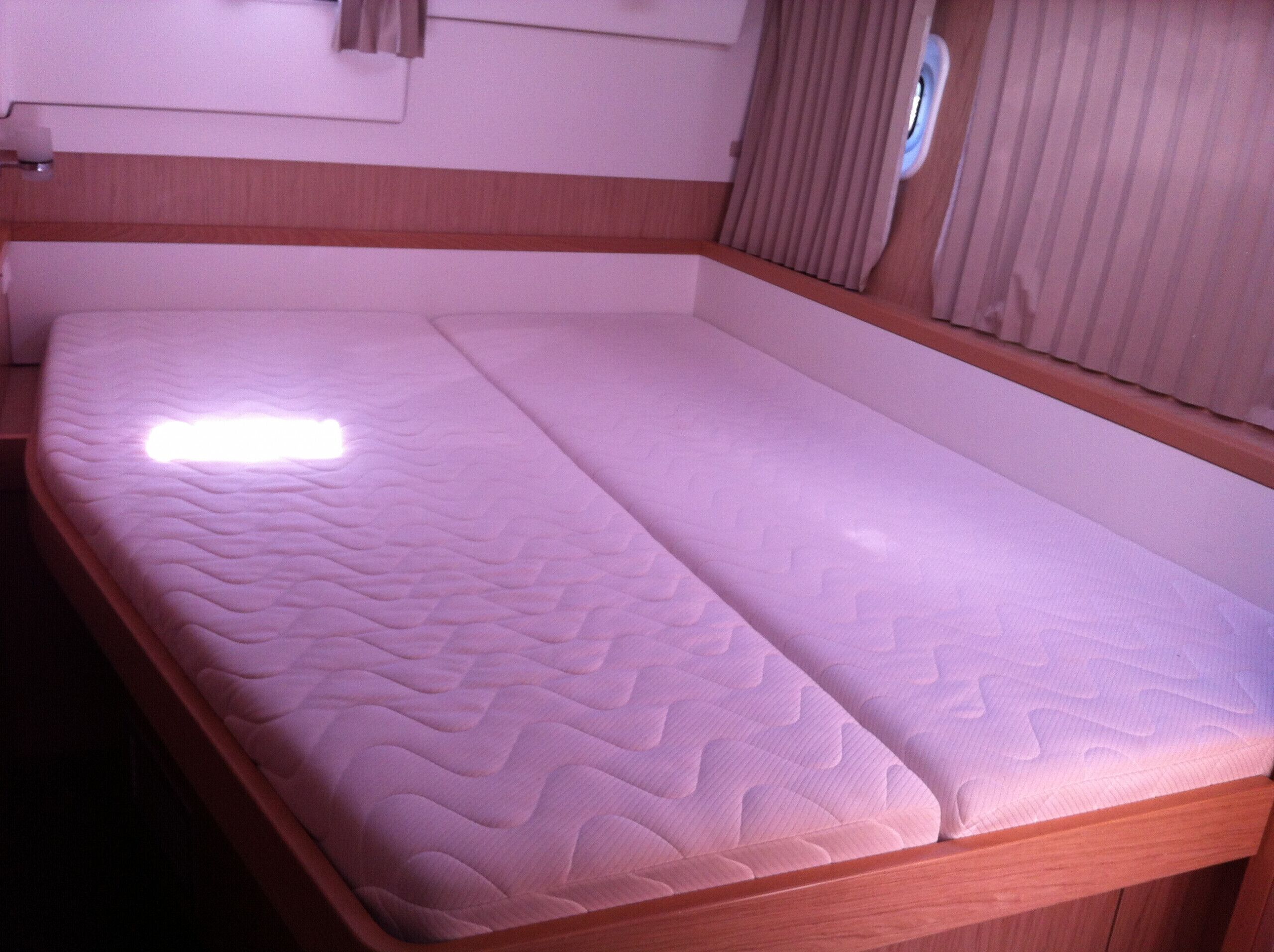 A single bed with a mattress and wooden frame in a room.