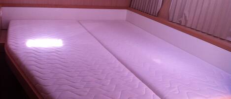 A single bed with a mattress and wooden frame in a room.