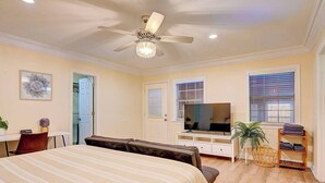 A bedroom with a bed, a TV, a ceiling fan, a door, and a window. - Oak Cliff Oasis I Swim Spa, Sauna, & Gameroom! 10 Min to Bishop Arts District (Dallas)