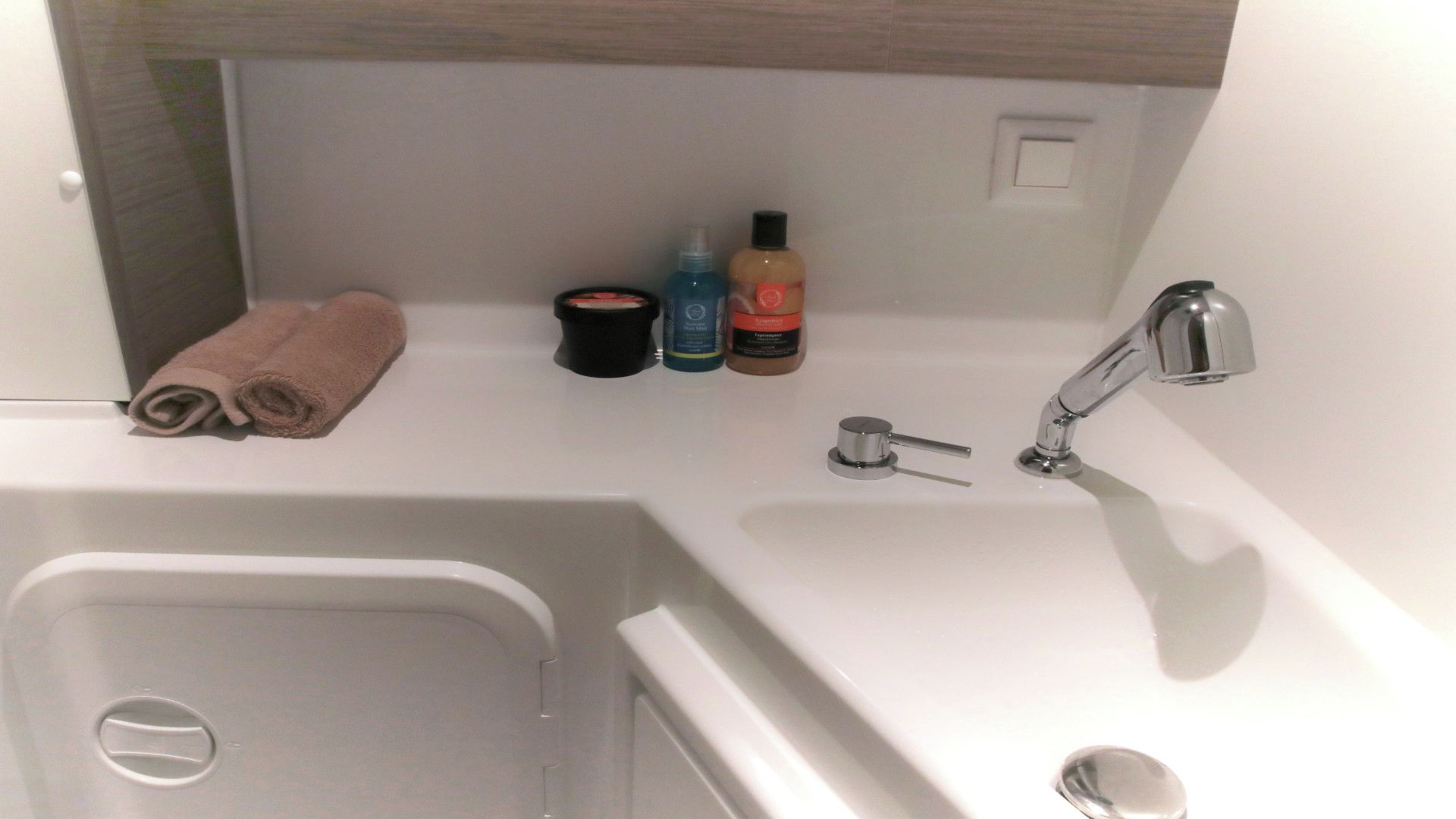 Un baño con bañera, lavamanos y artículos de aseo.