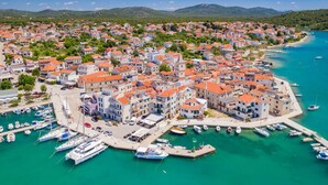 A coastal town with a marina, buildings with red roofs, and a clear blue sea. - Sibenik Sun-soaked Sailing: A Luxurious Croatian Voyage (Pirovac)