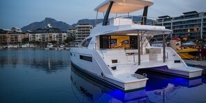 A white yacht docked at a marina with a covered deck and a view of the surrounding buildings. - Sun-Kissed Sailing Adventure in Split-Dalmatia, Croatia (Marina)