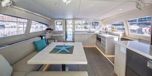 A modern boat interior with a dining area, kitchen, and seating. - Sun-Kissed Sailing Adventure in Split-Dalmatia, Croatia (Marina)