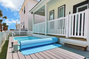 Un espace piscine doté d’une plateforme flottante, d’une terrasse en bois et d’une clôture blanche.