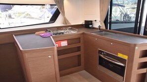 Una cocina compacta con fregadero, estufa y cajones para guardar objetos.