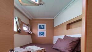 Una cabaña pequeña con una cama, una ventana y un estante.