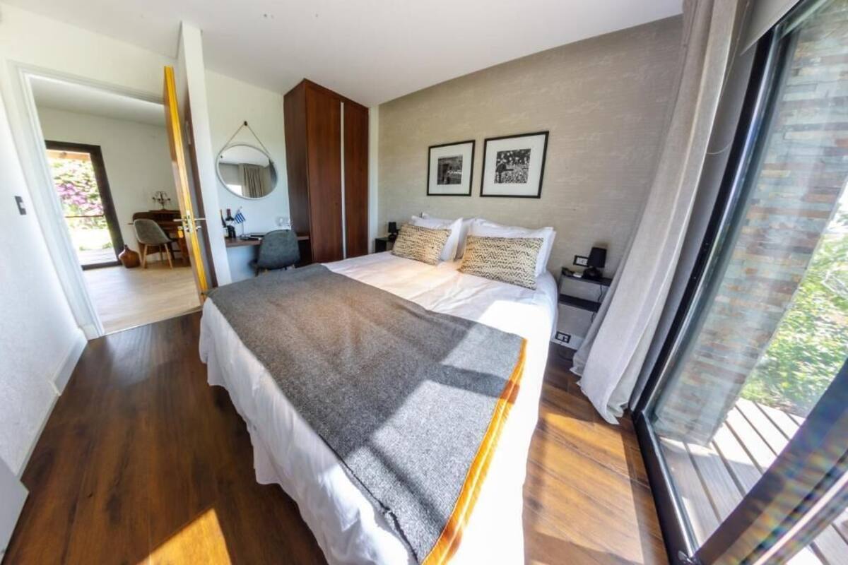 Un dormitorio moderno con una cama grande, un escritorio y una silla.
