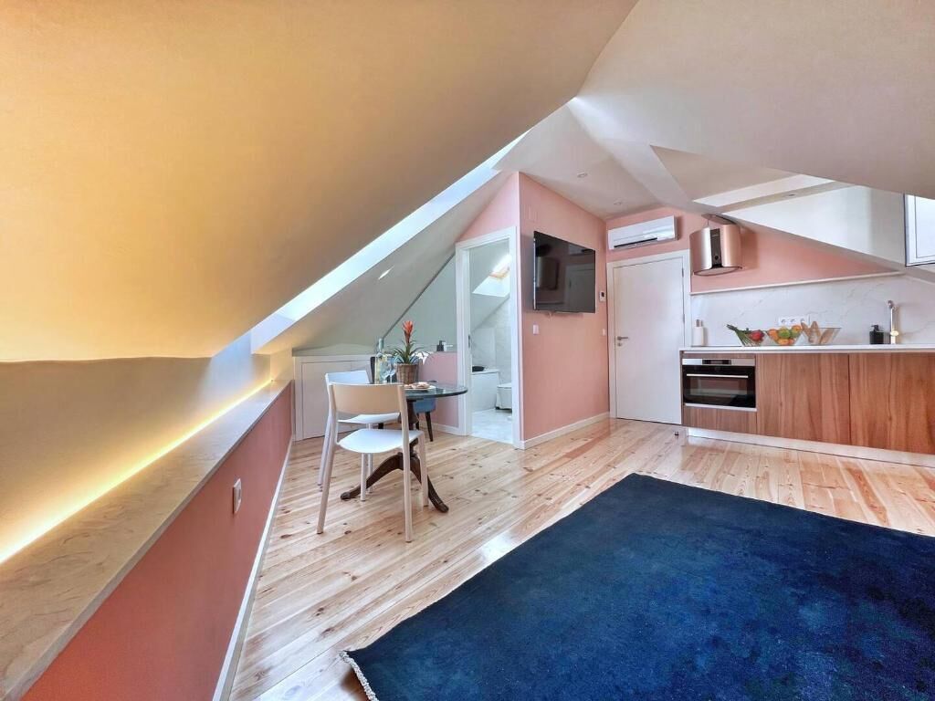 Eine moderne Küche mit Holzausstattung, einem eingebauten Ofen und einem Essbereich mit Tisch und Stühlen.
