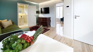Una sala de estar moderna con un sofá, un televisor de pantalla plana y un comedor con mesa y sillas.