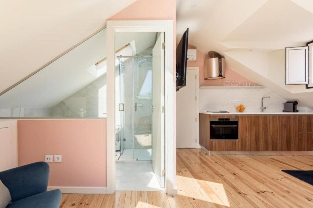 Un appartamento moderno con cucina, zona pranzo e una scala che conduce a un livello superiore.