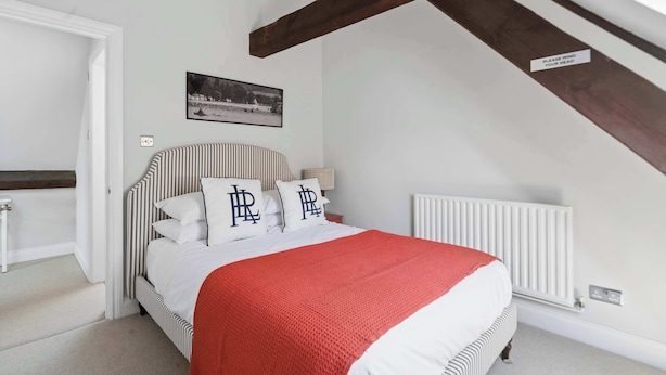 Een slaapkamer met een bed, nachtkastje, radiator en een foto aan de muur.