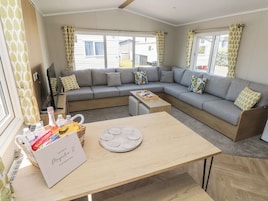 A modern living room with a sectional sofa, a wooden coffee table, and a wicker basket with items.