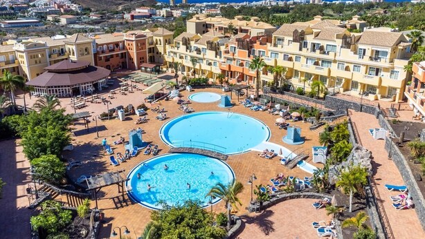 Un complexe hôtelier doté de plusieurs piscines, d’un patio couvert et offrant une vue sur le paysage environnant.