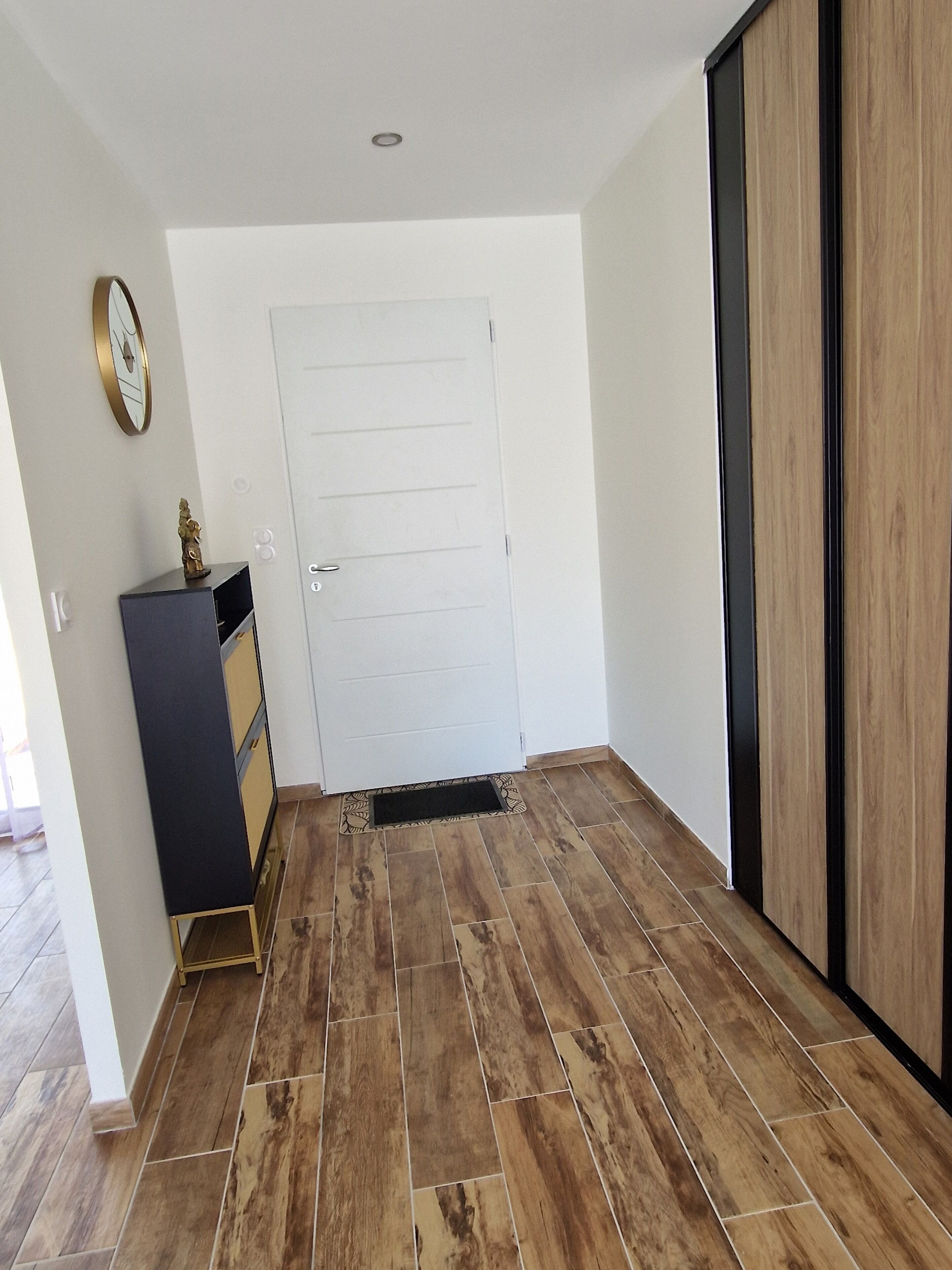 A room with a white door, a black cabinet, and a wooden wardrobe.