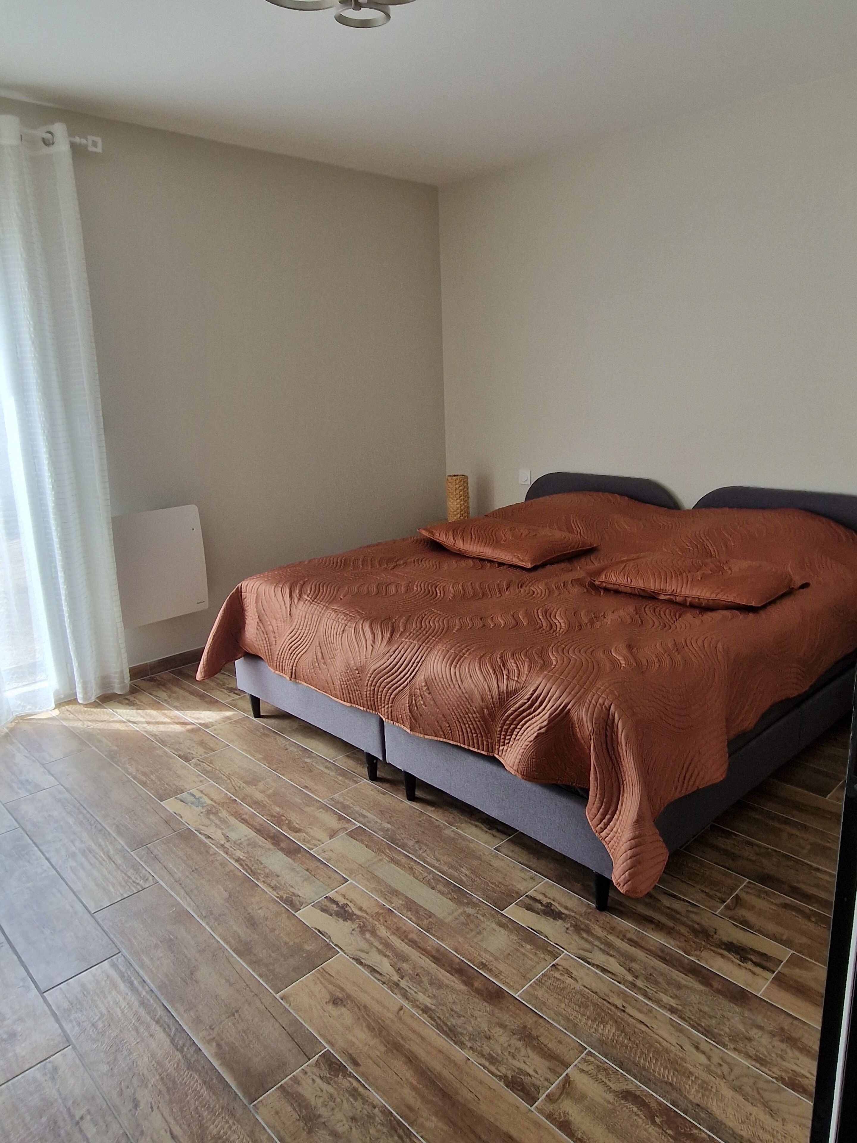 Ein Schlafzimmer mit einem Bett, einem Nachttisch und einer Lampe.