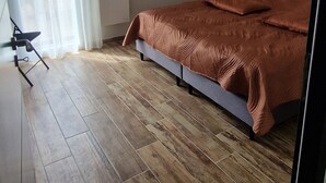 A bedroom with a bed, a standing lamp, a radiator, and a window with curtains. - Large new house for 8 to 9 people, 105 m² (Ludiès)