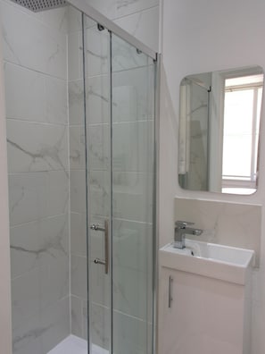 Een douche, een haardroger, handdoeken, toiletpapier