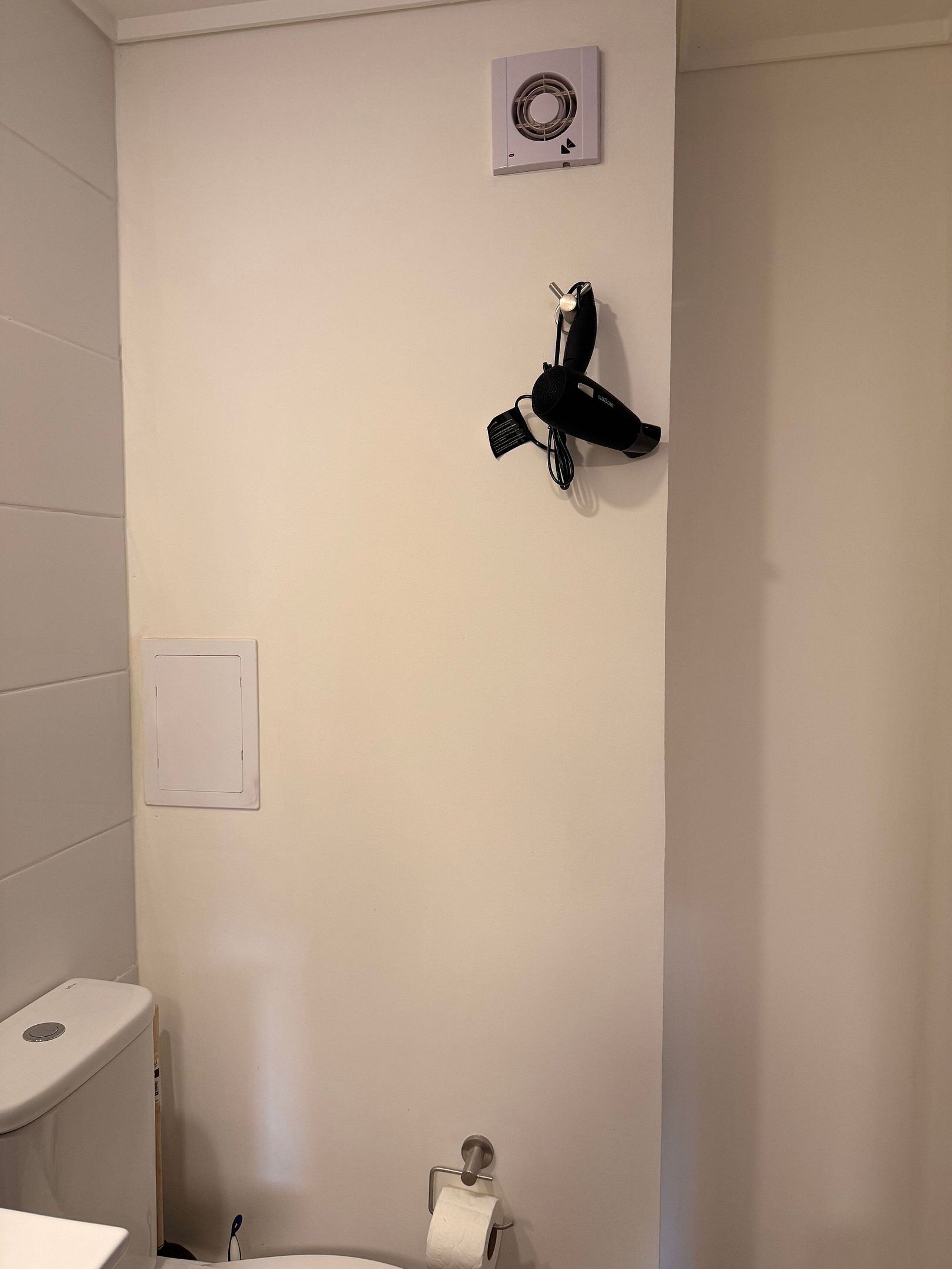 Un bagno con il water, un porta asciugamani e un portasciugamani.