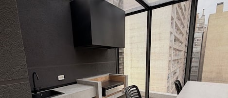 A modern kitchen with a built-in oven, a sink, and a dining area with a table and chairs.