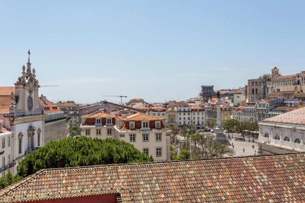A cityscape with historic buildings, a prominent church tower, and a plaza.