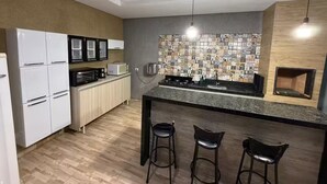 Eine moderne Küche mit einer zentralen Kochinsel, Barhocker, einer Mikrowelle und einem Kühlschrank.