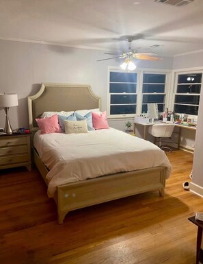 A bedroom with a bed, a desk, a chair, a ceiling fan, and a window. - Delightful 3-bedroom house with AC in charming Starkville (Starkville)