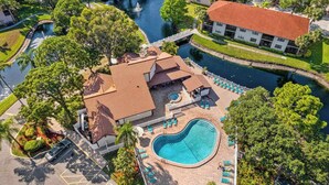 An aerial view of a resort with a swimming pool, a bridge, and a river. - Ground-floor condo with lagoon view, lanai, 2 pools, tennis, pickleball (Bradenton)