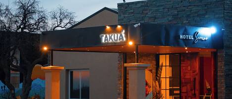 Entrada de un hotel con un cartel que dice 'TAKUA HOTEL' y 'HOTEL SECTOR'.