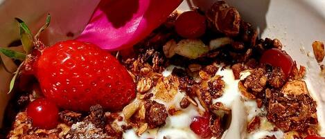 Un bol de céréales avec des fraises, du yaourt et du granola.
