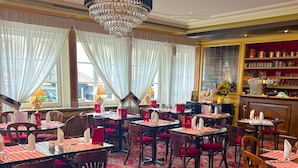 Un restaurante con manteles a cuadros, sillas de madera y un candelabro.