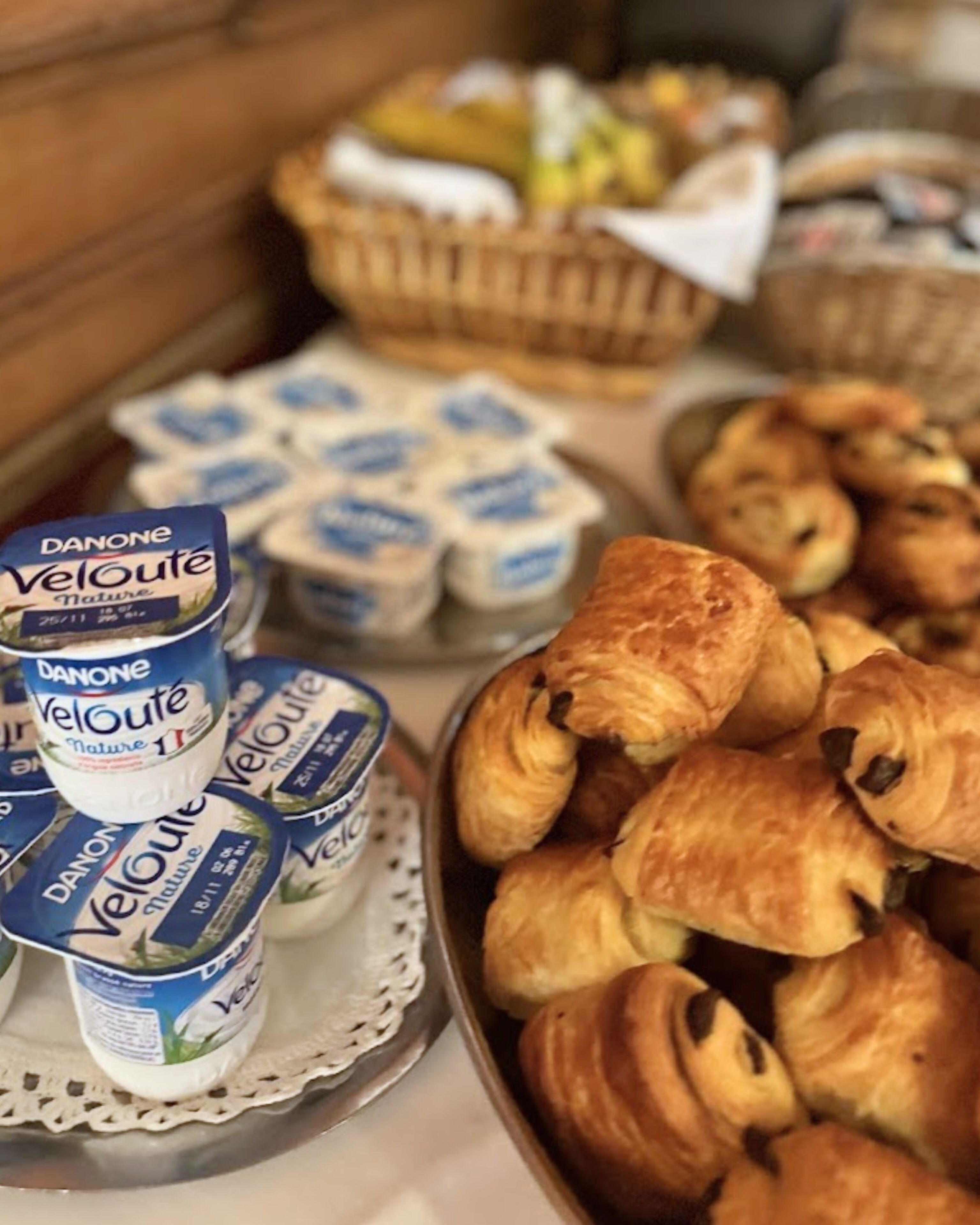 Un buffet proposant des yaourts Danone Velouté, des croissants et un assortiment de viennoiseries.