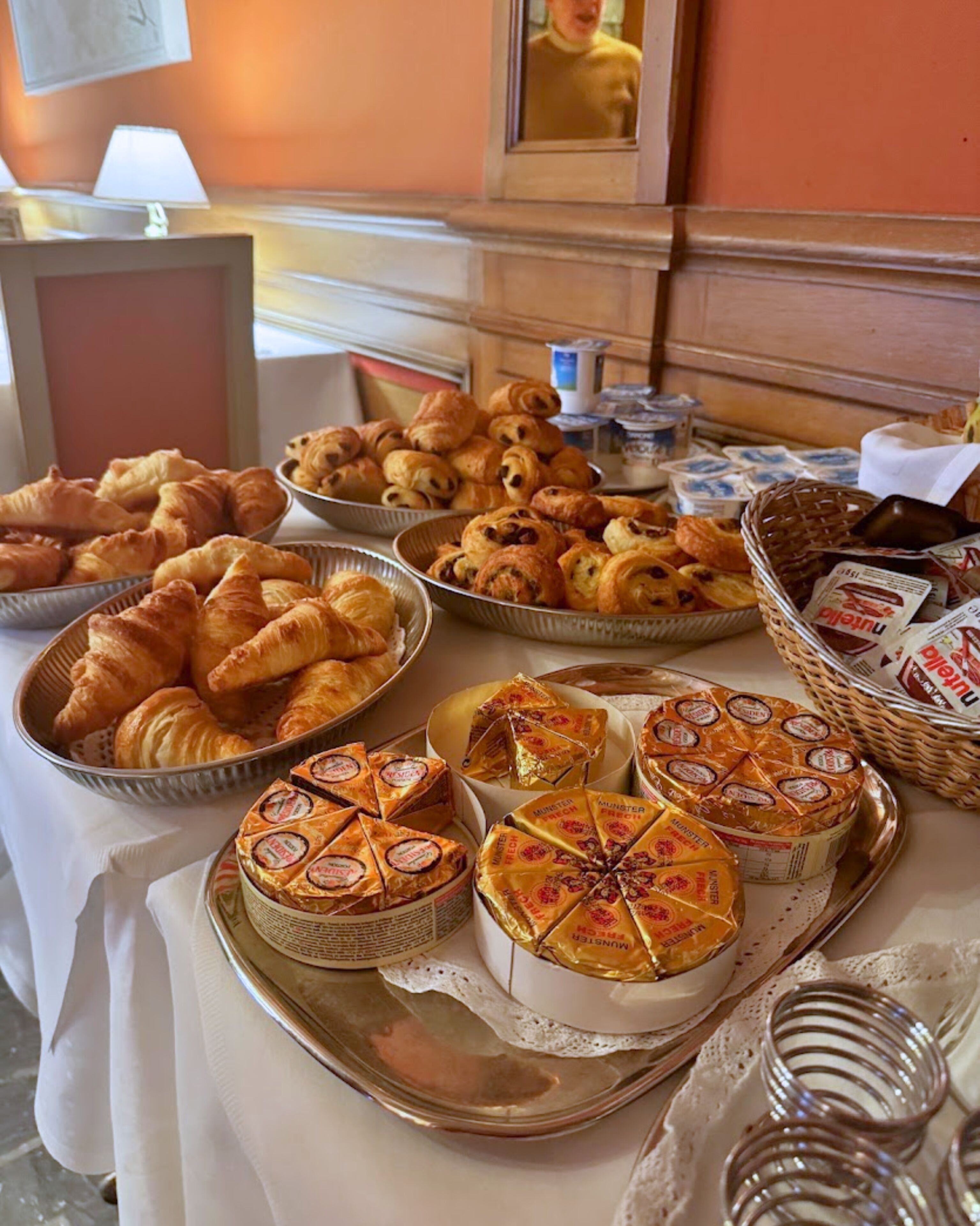 A buffet table with various baked goods and cheeses.