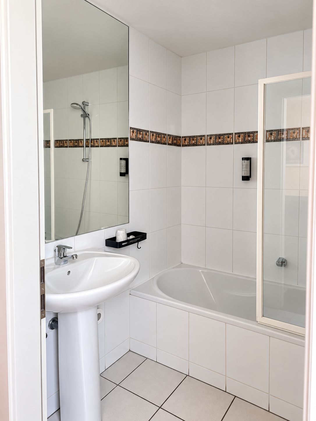 Un baño con lavamanos blanco, espejo, ducha y bañera.