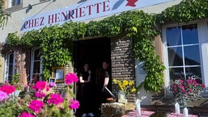 A restaurant named 'Chez Henriette' with outdoor seating and a sign indicating it is a bistro.